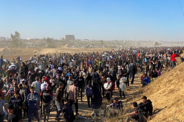 Personas con bolsas de suministros de socorro regresan de los centros de distribución de ayuda en Rafah a sus tiendas de campaña en el sur de la Franja de Gaza el 29 de mayo de 2025. (AFP)