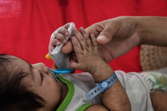 Imagen ilustrativa: Una madre atiende a su hijo de cuatro meses, quien padece sarampión y recibe tratamiento en un hospital público el 4 de mayo de 2019 en Manila, Filipinas. (Ezra Acayan/Getty Images)