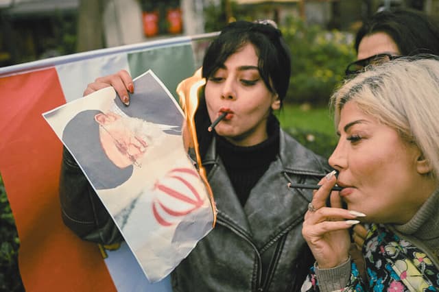 Una mujer quema un retrato del líder supremo de Irán, el ayatolá Alí Jamenei, tras encender un cigarrillo mientras participaba en una manifestación en solidaridad con los manifestantes iraníes y "contra la República Islámica por matar al pueblo iraní" en Yalova, el 16 de enero de 2026. El movimiento de protesta en Irán remitió tras una represión que causó miles de muertos y bloqueo de Internet, una semana después del inicio de las mayores protestas en años contra el sistema teocrático de la República Islámica. (Foto de YASIN AKGUL / AFP a través de Getty Images)
