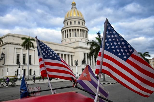 Dos banderas estadounidenses y una cubana ondean en el techo de un triciclo frente al Capitolio de La Habana el 3 de febrero de 2026. (YAMIL LAGE / AFP vía Getty Images)