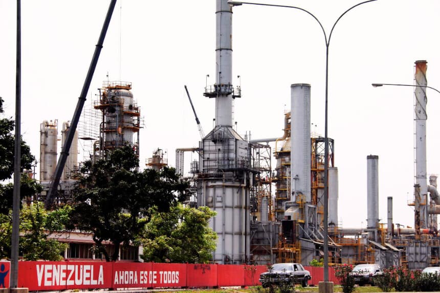 Coches pasan frente a una refinería de petróleo en la ciudad venezolana de Morón el 30 de abril de 2009. (THOMAS COEX/AFP a través de Getty Images)