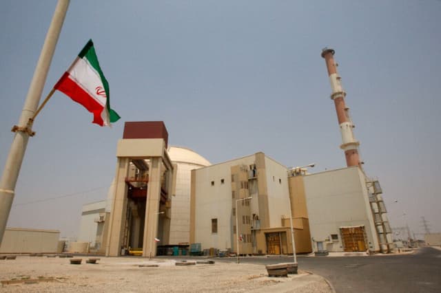 Una bandera iraní ondea frente al edificio del reactor de la central nuclear de Bushehr, a las afueras de la ciudad meridional de Bushehr, Irán, el 21 de agosto de 2010. (Vahid Salemi/AP Photo)