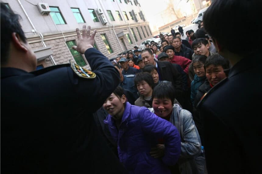 Funcionarios de la Oficina de Trabajo y Seguridad Social de Beijing instan a los trabajadores migrantes a reclamar los salarios que se les adeudan, el 9 de febrero de 2007 en Beijing, China. (China Photos/Getty Images)