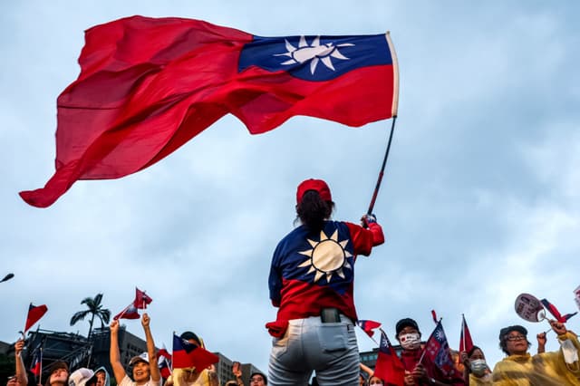 Imagen ilustrativa: Un simpatizante del principal partido de oposición de Taiwán, el Kuomintang (KMT), ondea la bandera nacional del país durante un mitin contra la elección de revocatoria frente a la Oficina Presidencial en Taipéi el 25 de julio de 2025. (I-HWA CHENG/AFP via Getty Images)