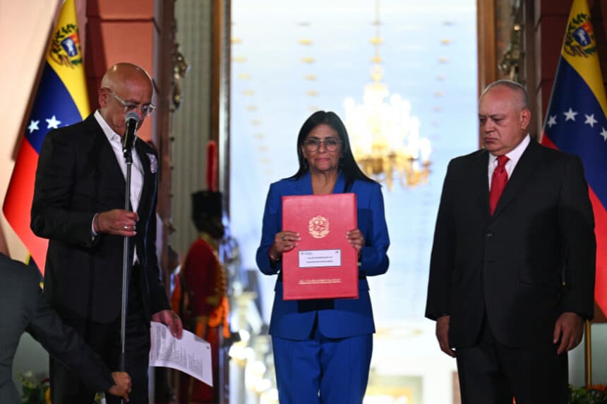 Venezuela's interim president Delcy Rodriguez (C) holds the amnesty law approved by the National Assembly, accompanied by the president of the Assembly Jorge Rodriguez (L) and the Minister of Interior, Justice and Peace Diosdado Cabello, at the Miraflores Palace in Caracas on February 19, 2026. Venezuela's Parliament unanimously approved on February 19 a historic amnesty law that is expected to lead to the release of hundreds of political prisoners after 27 years of Chavismo. (Photo by Juan BARRETO / AFP via Getty Images)