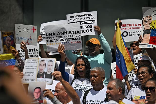 Familiares de presos políticos sostienen carteles y retratos de sus seres queridos frente a la sede de las Naciones Unidas en Caracas, el 18 de febrero de 2026, mientras el Congreso venezolano considera una ley de amnistía a los presos políticos, tras varios aplazamientos, entre huelgas de hambre, una de ellas en su día 5. (Foto de Juan BARRETO / AFP vía Getty Images)