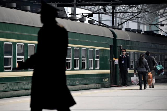Pasajeros suben a un tren verde en la estación central de ferrocarril de Shanghái el 29 de enero de 2009. (Philippe Lopez/AFP a través de Getty Images)
