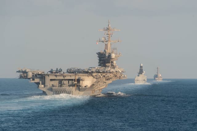 El portaaviones USS Abraham Lincoln (CVN 72), a la izquierda, el destructor de defensa aérea de la Marina Real HMS Defender (D 36) y el destructor de misiles guiados USS Farragut (DDG 99) transitan el estrecho de Ormuz, el 19 de noviembre de 2019. (Zachary Pearson - Marina de los EE. UU. vía Getty Images)