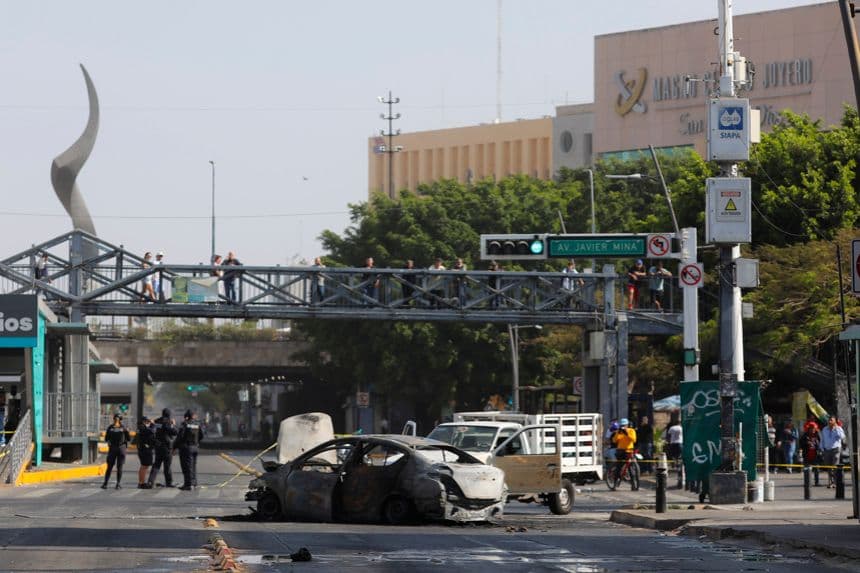 Fotografía que muestra un bloqueo con vehículos incendiados este domingo, en una vía de Guadalajara, México. (EFE/ Francisco Guasco)