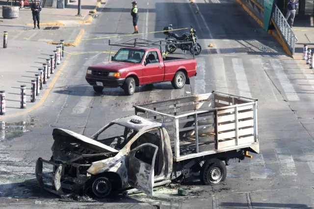 Los restos calcinados de un camión, utilizado como barricada por miembros de un cártel en represalia por el asesinato del famoso líder del cártel "El Mencho" por parte de las fuerzas mexicanas, yacen en Guadalajara, México, el 22 de febrero de 2026. (Michelle Freyria/Reuters)