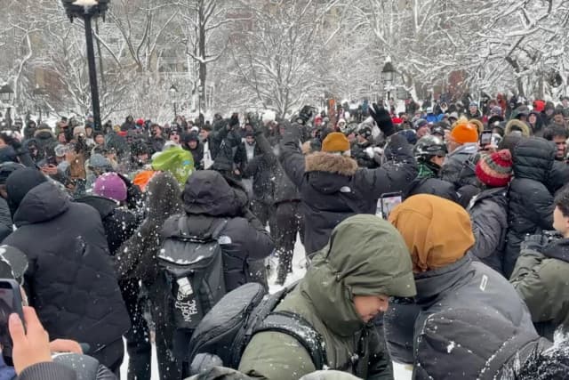 En esta foto tomada de un video, la gente lanza y se agacha de las bolas de nieve durante una pelea de bolas de nieve en Washington Square Park en Nueva York el 23 de febrero de 2026. (David R. Martin/Foto AP)