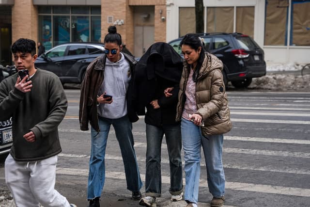 Ellie Aghayeva, estudiante de neurociencia de la Universidad de Columbia, es escoltada a su apartamento con el rostro cubierto tras ser detenida por agentes federales del Departamento de Seguridad Nacional la madrugada del jueves 26 de febrero de 2026 en la ciudad de Nueva York. (Ryan Murphy/Getty Images)