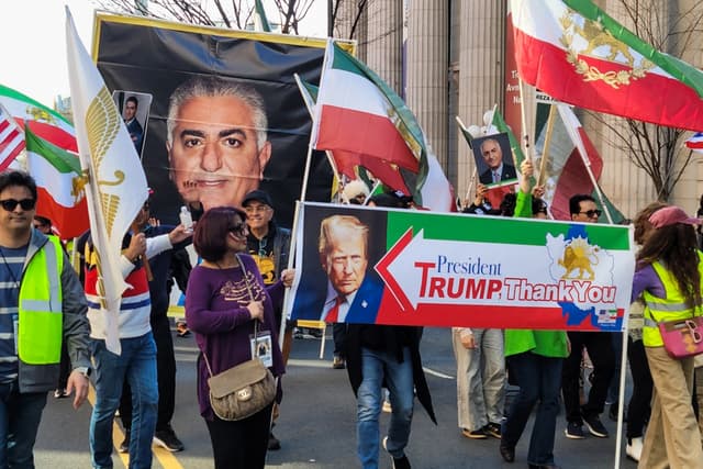 Personas que apoyan los ataques militares conjuntos de Estados Unidos e Israel contra Irán ondean pancartas y carteles durante una marcha desde el Parque Conmemorativo de la Primera Guerra Mundial hacia la Casa Blanca en Washington, D.C., el 28 de febrero de 2026. (Stacy Robinson/The Epoch Times)