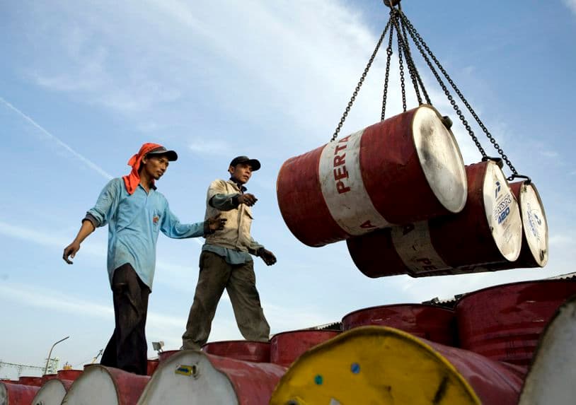 Dos operarios descargan barriles cargados de petróleo. Imagen de archivo. (EFE/Adi Weda)