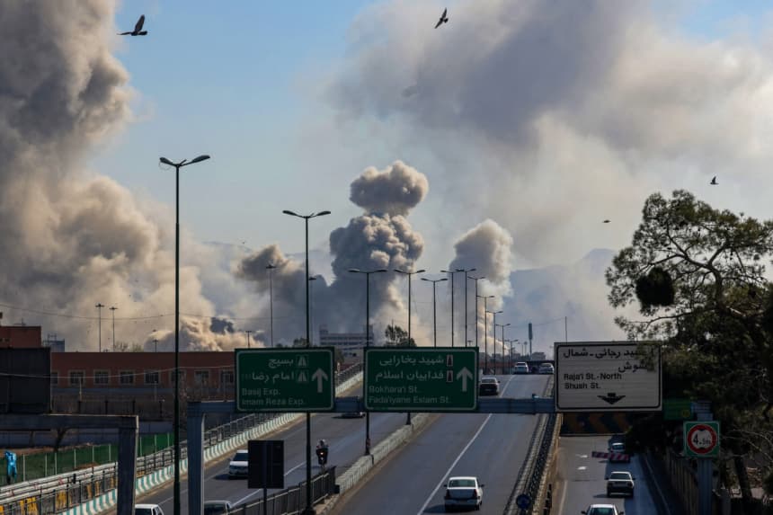 Automovilistas circulan por una vía rápida mientras se elevan columnas de humo tras un ataque en Teherán, el 5 de marzo de 2026. (ATTA KENARE / AFP via Getty Images)