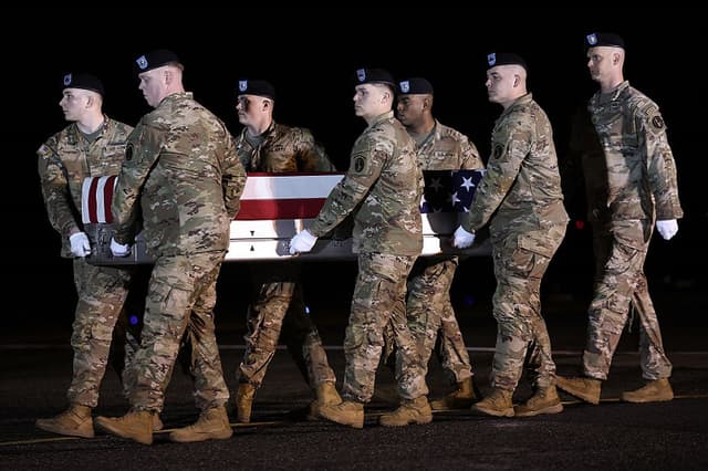 Un equipo de transporte del Ejército de Estados Unidos traslada un ataúd cubierto con la bandera que contiene los restos mortales del mayor Sorffly Davius, de 46 años, de Cambria Heights, Queens, Nueva York, en la base aérea de Dover el 9 de marzo de 2026 en Dover, Delaware. (Getty images)