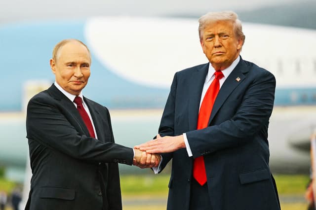 El presidente Donald Trump saluda al presidente ruso Vladimir Putin en la pista de aterrizaje tras su llegada a la Base Conjunta Elmendorf-Richardson en Anchorage, Alaska, el 15 de agosto de 2025. (ANDREW CABALLERO-REYNOLDS / AFP a través de Getty Images)