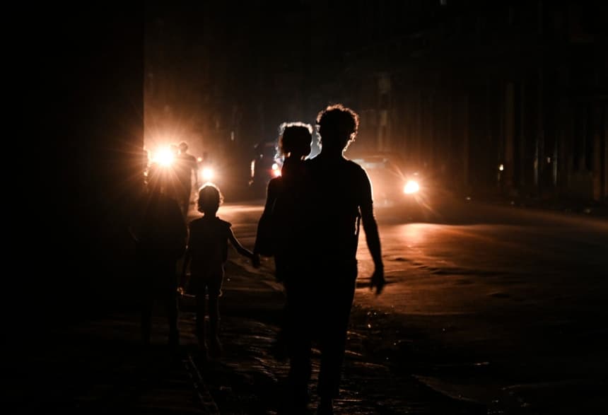 Imagen ilustrativa. Cubanos caminan por una calle durante la tercera noche de un apagón nacional en La Habana, el 20 de octubre de 2024. (YAMIL LAGE/AFP vía Getty Images)
