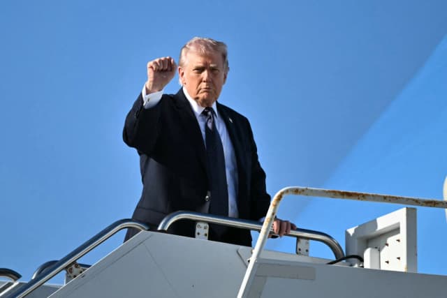El presidente Donald Trump hace un gesto al abordar el Air Force One antes de partir del Aeropuerto Internacional de Palm Beach en West Palm Beach, Florida, el 1 de marzo de 2026, rumbo a Washington. (Mandel Ngan/AFP vía Getty Images)