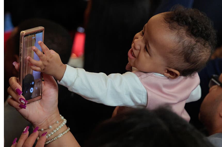 Un niño toca la pantalla de un teléfono en el Salón Este de la Casa Blanca el 18 de febrero de 2026 en Washington, DC. cuando el presidente Donald Trump emitió una proclamación en la que reconocía el Mes de la Historia Afroamericana. (Foto de Chip Somodevilla/Getty Images)