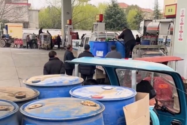 Vehículos en China hacen fila en gasolineras con bidones de combustible. (Captura de pantalla del video de The Epoch Times)