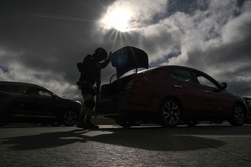 Un oficial de la Guardia Nacional inspecciona un vehículo que se dirige a Estados Unidos en el lado mexicano del paso fronterizo de San Ysidro, en Tijuana, estado de Baja California, México, el 6 de febrero de 2025. (GUILLERMO ARIAS/AFP vía Getty Images)