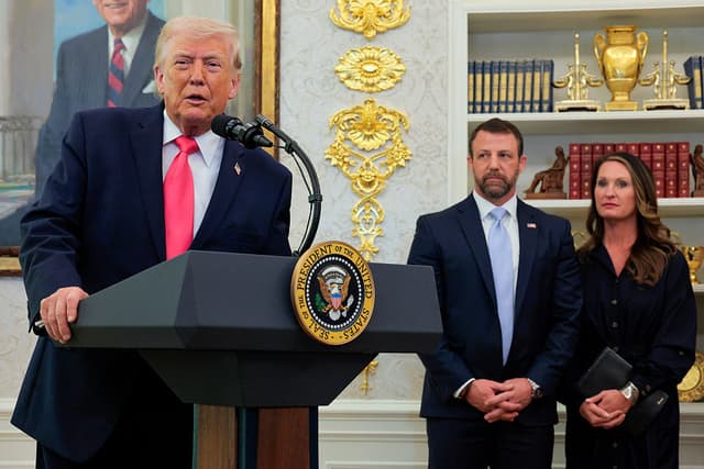El presidente de EE. UU., Donald Trump (izquierda), habla mientras el recién nombrado secretario del Departamento de Seguridad Nacional, Markwayne Mullin, y su esposa, Christie Mullin, observan durante una ceremonia en el Despacho Oval de la Casa Blanca el 24 de marzo de 2026 en Washington, D.C. (Foto de Chip Somodevilla/Getty Images)