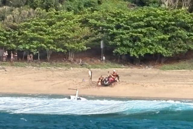 Miembros del equipo de seguridad marítima de Kauai y otras personas prestan asistencia a los damnificados tras el accidente de un helicóptero turístico de Airborne Aviation en la playa de Kalalau, en Kauai, Hawái, el 26 de marzo de 2026. (Suboficial de segunda clase Tyler Robertson/Estación de Kauai/Guardia Costera de EE. UU. vía AP)