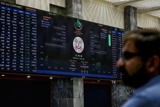 Un corredor de bolsa observa los precios de las acciones en un panel digital durante una sesión bursátil en la Bolsa de Valores de Pakistán (PSX) en Karachi, el 1 de abril de 2026. (Rizwan TABASSUM / AFP vía Getty Images)