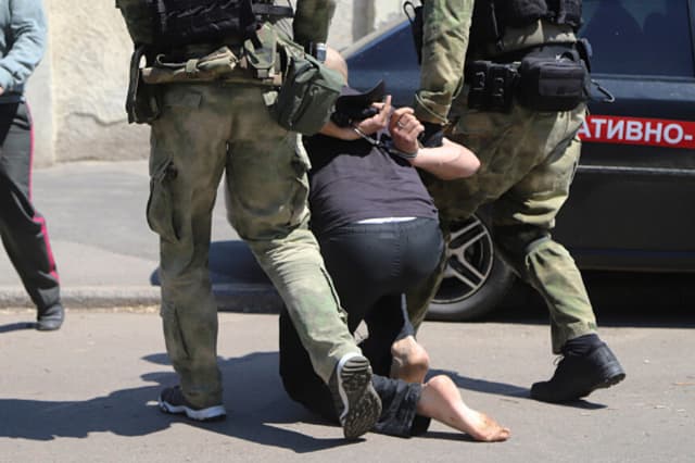 Imagen Ilustrativa: La policía y la Guardia Nacional ucranianas detienen a uno de los seis hombres arrestados frente a la colonia penitenciaria donde se habían reunido para expresar su apoyo a los reclusos tras los disturbios ocurridos en el interior, en la ciudad de Odesa, al sur de Ucrania, el 27 de mayo de 2019. (Crédito: ALEKSANDR GIMANOV/AFP vía Getty Images).