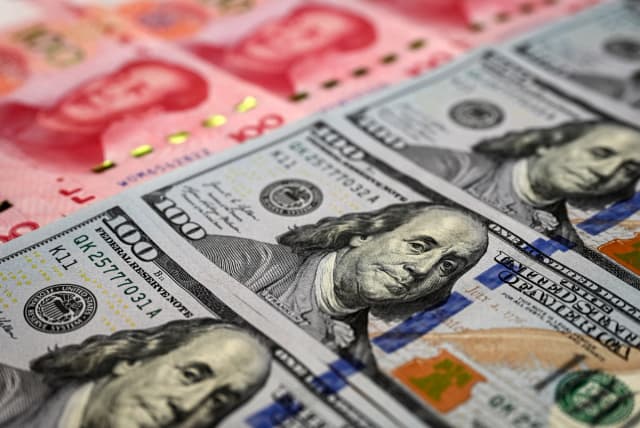 Billetes chinos de 100 yuanes y billetes estadounidenses de 100 dólares en Beijing el 8 de abril de 2025. (Jade Gao/AFP vía Getty Images)