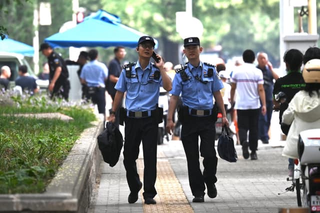 Agentes de policía patrullan las inmediaciones del Hotel Jingxi, donde los líderes chinos celebraron el Tercer Pleno, una importante reunión económica, en Beijing, el 15 de julio de 2024. (Greg Baker/AFP vía Getty Images)