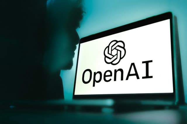 Un ordenador con el logotipo de OpenAI aparece ante un fondo azul degradado con la sombra de un hombre al fondo en Grenoble, Francia, el 12 de febrero de 2025. (Anouk Anglade/Hans Lucas/AFP vía Getty Images)