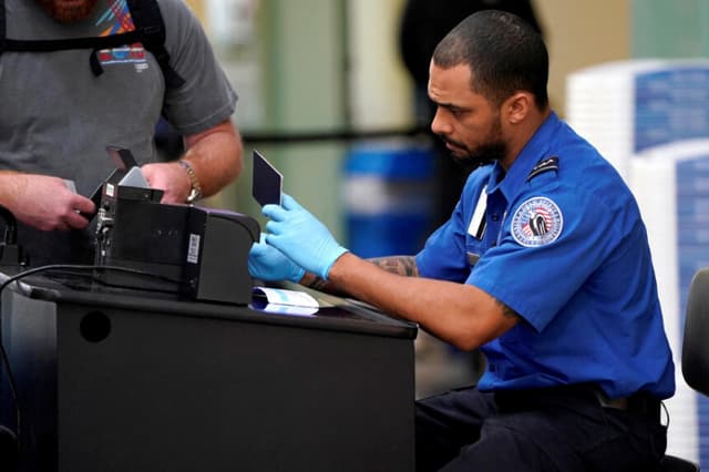 Un funcionario de la Administración de Seguridad en el Transporte (TSA) revisa los documentos de un viajero en el Aeropuerto Nacional Reagan de Washington, el 6 de enero de 2019. (Joshua Roberts/Reuters).