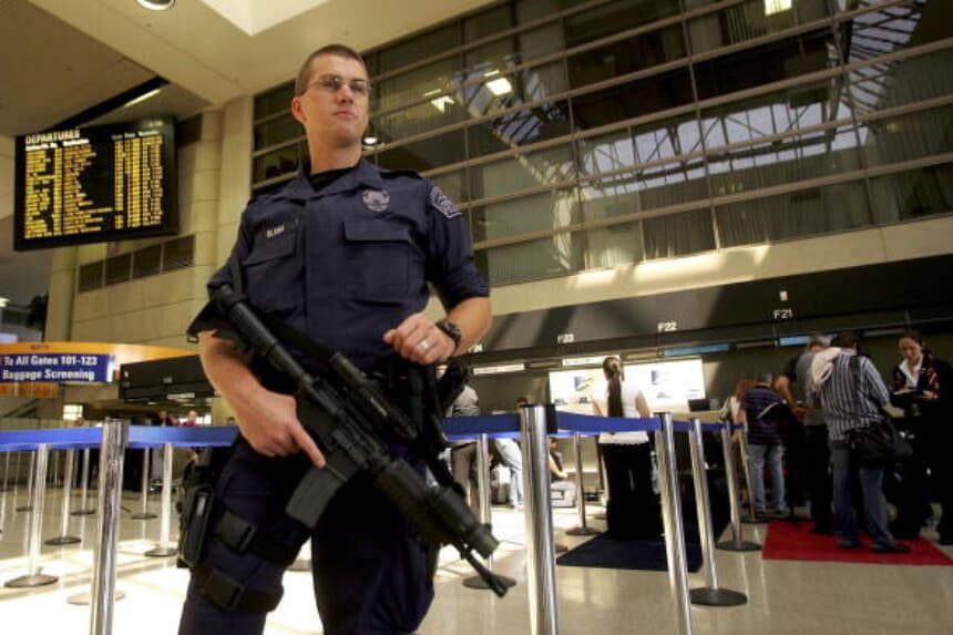 Imagen Ilustrativa: Un agente de la Policía del Aeropuerto de Los Ángeles, armado con un rifle, se encuentra en la Terminal Internacional Bradley del Aeropuerto Internacional de Los Ángeles tras la prohibición del DHS a los pasajeros de llevar líquidos, geles o lociones en vuelos, el 10 de agosto de 2006. (David McNew/Getty Images).
