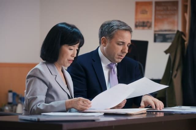 Ying Chen, vicepresidenta de Shen Yun, junto al periodista de investigación de NTD Steve Lance, en una escena del documental “Unbroken”. (Paulio Shakespeare/NTD)