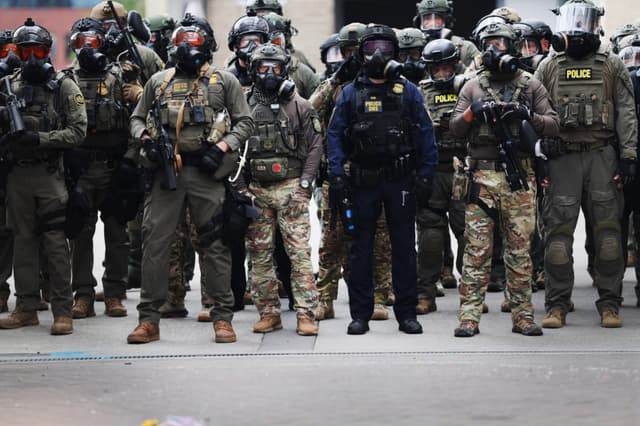 Agentes federales, entre ellos miembros del Departamento de Seguridad Nacional, la Patrulla Fronteriza y la policía, frente a un centro del Servicio de Inmigración y Control de Aduanas de Estados Unidos en el centro de Portland, Oregón, el 4 de octubre de 2025. (Spencer Platt/Getty Images)