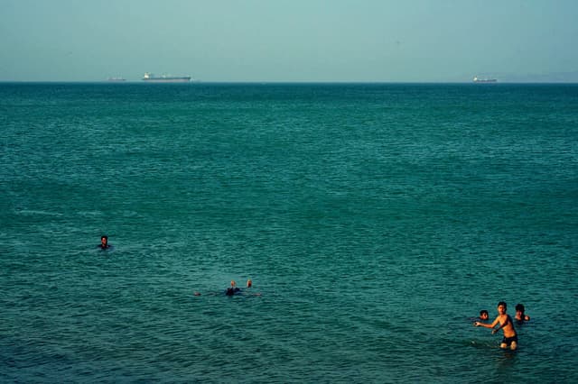Personas se bañan en el mar el 28 de abril de 2026 en la isla de Qeshm, Irán, en el estrecho de Ormuz. (Asghar Besharati/Getty Images)