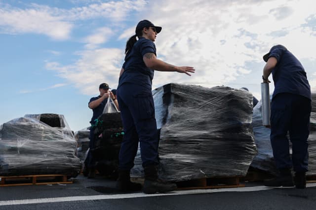 Miembros de la tripulación de la Guardia Costera de EE. UU. descargan en Port Everglades, Florida, el 9 de abril de 2025, la carga que formaba parte de una incautación de cocaína y marihuana por valor de más de 509 millones de dólares, realizada durante 13 operaciones de interceptación en el Atlántico a bordo del buque James de la Guardia Costera.. (Joe Raedle/Getty Images).