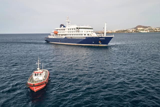 Una embarcación se dirige hacia el puerto desde el crucero MV Hondius, que se encuentra fondeado frente al puerto de Praia, la capital de Cabo Verde, el 6 de mayo de 2026. (AFP vía Getty Images).