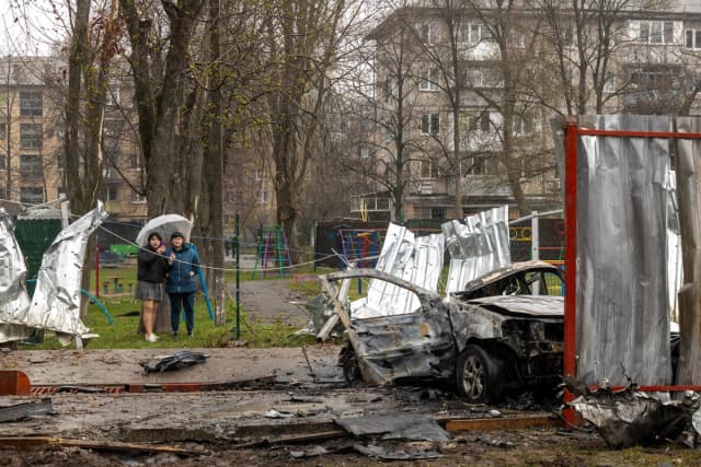 Los lugareños se encuentran en el lugar del impacto de un dron ruso en un barrio residencial, en medio del ataque de Rusia a Ucrania, en Vyshneve, Ucrania, el 3 de abril de 2026. (Reuters/Thomas Peter)