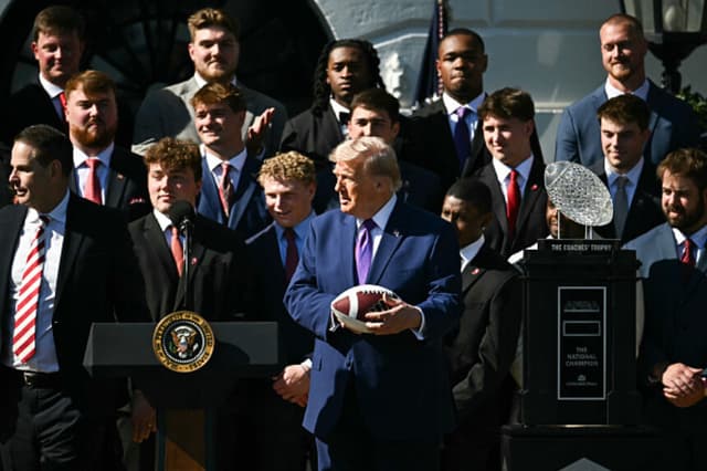 Imagen Ilustrativa: El presidente de Estados Unidos, Donald Trump, sostiene un balón de fútbol americano que le han regalado durante un acto en honor a la Universidad de Indiana, campeona nacional de los Playoffs de Fútbol Americano Universitario de la NCAA de 2026, celebrado en el Jardín Sur de la Casa Blanca, en Washington, D.C., el 11 de mayo de 2026. (Kent NISHIMURA / AFP/Getty Images).