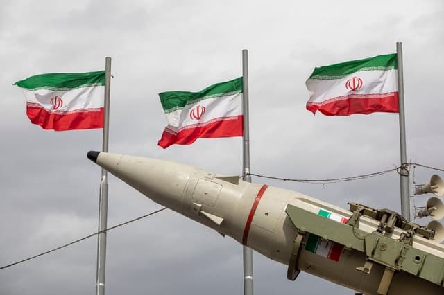 Misiles fabricados por las fuerzas armadas iraníes se exhiben junto a una hilera de banderas iraníes durante las conmemoraciones del aniversario de la Revolución Iraní de 1979 en Teherán, Irán, el 11 de febrero de 2026. (Majid Saeedi/Getty Images)