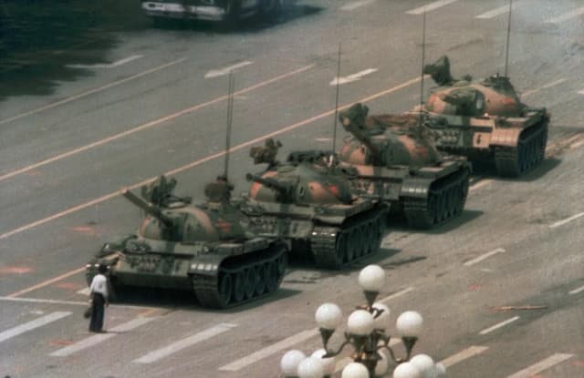 Un hombre chino se interpone para bloquear una fila frente a tanques que avanzan en el bulevar Cangan de Beijing, en la plaza de Tiananmen en junio de 1989. (Foto de Jeff Widener/AP.)