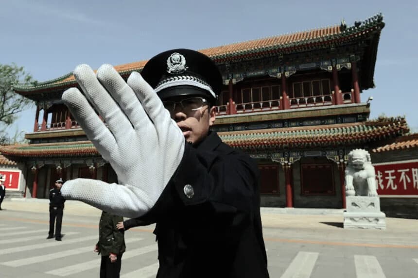 Un policía chino impide tomar fotografías en las afueras de Zhongnanhai, sede del PCCh, en Beijing, el 11 de abril de 2012, tras la destitución de Bo Xilai del Politburó. (MARK RALSTON/AFP vía Getty Images).