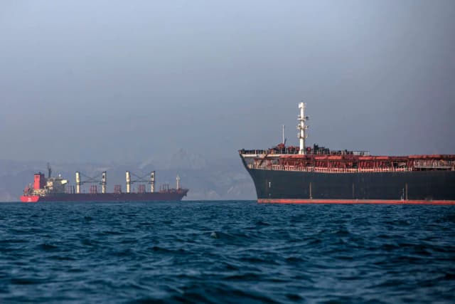 Un remolcador iraní se ve en primer plano mientras buques de carga permanecen anclados en el estrecho de Ormuz, frente a Bandar Abbas, Irán, el 4 de mayo de 2026. (Amirhosein Khorgooi/ISNA vía AP)