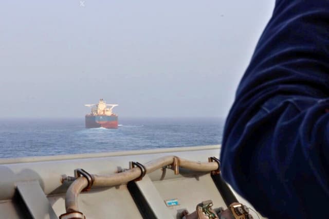 Un marinero estadounidense a bordo del USS Comstock (LSD 45) observa un buque mercante mientras aplica el bloqueo de Estados Unidos contra Irán, el 21 de mayo de 2026. (Cortesía del Mando Central de Estados Unidos).