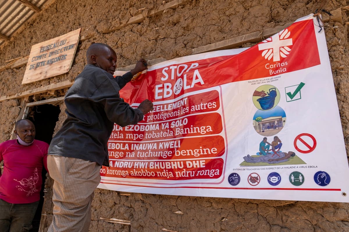 Un hombre cuelga una pancarta de concientización sobre el ébola en el campamento de Kigonze en Bunia, Congo, el 28 de mayo de 2026. (Glody Murhabazi/AFP vía Getty Images).