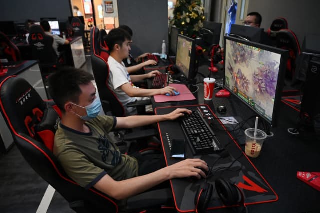 Personas jugando videojuegos en un cibercafé en Beijing el 10 de septiembre de 2021. (Greg Baker/AFP vía Getty Images)