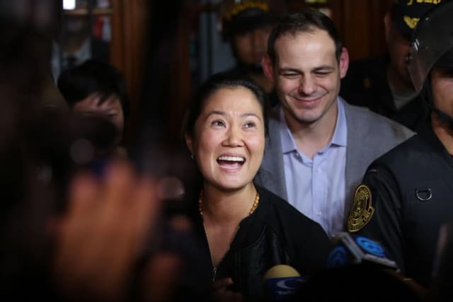 Keiko Fujimori, líder del partido opositor peruano Fuerza Popular, saluda con la mano, junto a su esposo Mark Vito, al salir del Tribunal Penal Nacional de Lima el 17 de octubre de 2018. (Luka Gonzales/AFP/Getty Images)